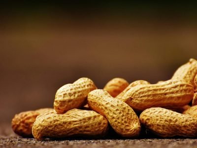 A focused close-up of unshelled peanuts on a rustic surface with earthy tones.